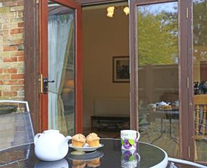 a table with a plate of muffins on it at 1 Bed in Beccles oc-hfs in Wangford
