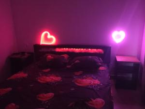 a bedroom with a bed with hearts on it at love room les plaisirs partagés in Arles