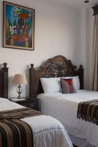 a bedroom with two beds and a picture on the wall at Hotel Taa' Tiin in San Juan La Laguna +68 photos