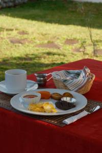 a plate of breakfast food on a red table at Hotel Taa' Tiin in San Juan La Laguna