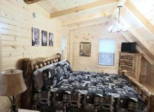a bedroom with a bed in a log cabin at Queen of Hearts in Rockbridge +2 photos