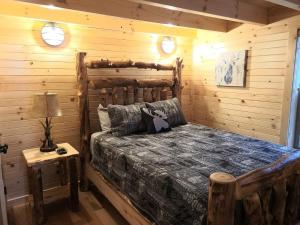 a bedroom with a bed in a log cabin at Queen of Hearts in Rockbridge