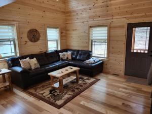 a living room with a black leather couch and a table at Jack of Hearts in Rockbridge +10 photos