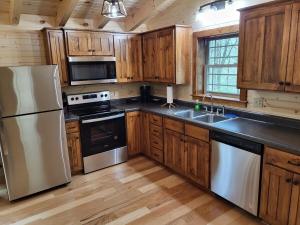 a kitchen with wooden cabinets and stainless steel appliances at Jack of Hearts in Rockbridge