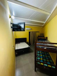 a room with two bunk beds and a tv at Hospedaje San Cosme y Damián in Zarate Isla