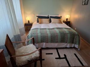 a bedroom with a bed and a chair and two lamps at L annexe in Saint-Jean-d'Aulps