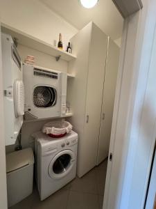 a kitchen with a washing machine and a microwave at Dimora delle Terme in Porretta Terme +4 photos