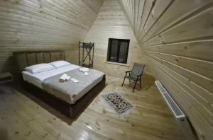 a bedroom with a bed and a chair in a room at kazbegi - Sno Mountain House in Sno
