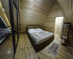 a bedroom with a bed in a wooden cabin at kazbegi - Sno Mountain House in Sno +16 photos