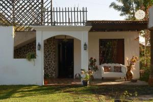 a porch of a house with a white couch at Hotel Taa' Tiin in San Juan La Laguna
