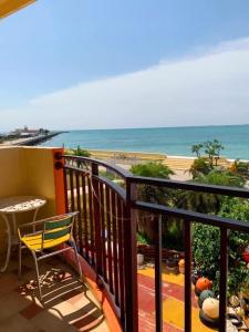 a balcony with a chair and a table and the beach at Captain's Homestay in Baisha