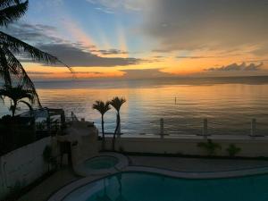 Sonnenuntergang über dem Wasser mit einem Swimmingpool in der Unterkunft Mateos Villa in Carmen