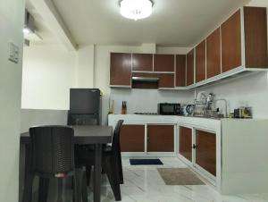a kitchen with wooden cabinets and a table with chairs at Home stay in Pasig in Pasig