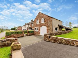 a large brick house with a white garage at 3 Bed in Appleby-in-westmorland oc-94764 in Brampton