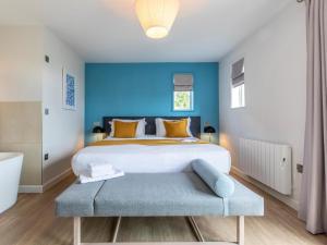 a bedroom with a large bed with a blue wall at 2 Bed in Saltash oc-87701 in St. Mellion +22 photos