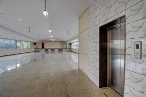 a large empty room with a marble wall at Sai Arya Residency By The Avyaan in Mangalore
