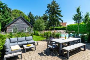 a patio with a couch and a table and chairs at 5 Bed in Walberswick oc-troy in Walberswick