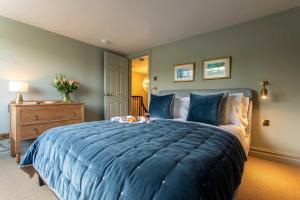 a bedroom with a large bed with blue sheets at Old Orchard Elegance - Private Parking in Bath