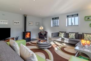 a living room with a couch and a fireplace at 3 Bed in Knodishall oc-ebco in Aldringham