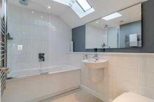 a bathroom with a sink and a tub and a mirror at 3 Bed in Knodishall oc-ebco in Aldringham +26 photos
