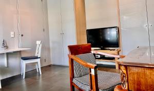 a living room with a television and a chair at V06 Seasidevilla Vlissingen in Vlissingen