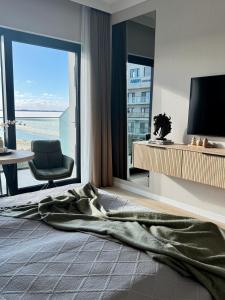 a bedroom with a large window with a view of the ocean at Baltic Infinity Suite 529 - SPA & Pool Access in Międzyzdroje