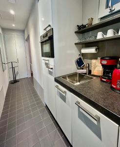 a kitchen with white cabinets and a sink at V06 Seasidevilla Vlissingen in Vlissingen