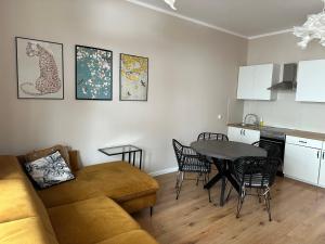 a living room with a couch and a table and a kitchen at Chopin's Apartment in Bielsko-Biała
