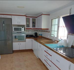 a kitchen with white cabinets and stainless steel appliances at Villa entre terre et mer in Montroy
