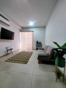 a living room with a couch and a tv at Apartment with balcony overlooking crystal-clear lagoon and in Mazatlán