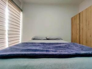 a bedroom with a bed with a purple blanket on it at Apartment with balcony overlooking crystal-clear lagoon and in Mazatlán