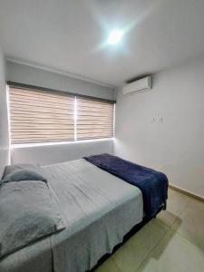 a bedroom with a bed and a window with a blue blanket at Apartment with balcony overlooking crystal-clear lagoon and in Mazatlán +33 photos