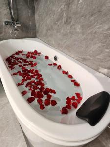 a bath tub filled with red rose petals on it at Lâm Luxury Hotel Lào Cai in Chơ Mơi +34 photos