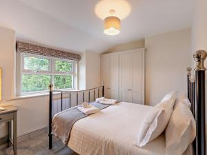 a bedroom with a bed with white sheets and a window at 2 Bed in Keswick oc-90064 in Threlkeld
