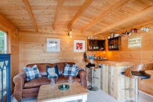 a living room with a couch and a bar in a cabin at 3 Bed in Wrentham oc-15mill in Wrentham +27 photos