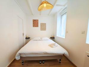 a white bedroom with a bed in a room at L'Horizon - AbsoluteHome in Croix