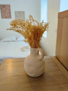 a white vase with flowers in it on a table at L'Horizon - AbsoluteHome in Croix +2 photos