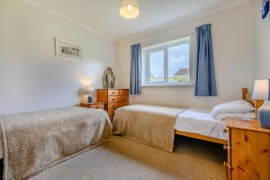 a bedroom with two beds and a window at 3 Bed in Padstow oc-p00131 in Saint Merryn