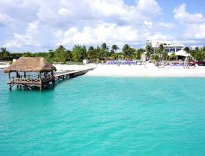 a dock in the water next to a beach at Xcalacoco Beach in Playa del Carmen
