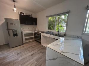a kitchen with a counter top and a refrigerator at Xcalacoco Beach in Playa del Carmen