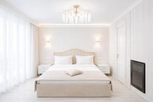 a white bedroom with a large bed and a television at Yerevan In Boutique Hotel in Yerevan +34 photos
