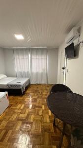 a room with a bed and a chair in it at Flat em excelente localização de Chapecó in Chapecó