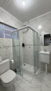 a bathroom with a shower and a toilet and a sink at Flat em excelente localização de Chapecó in Chapecó