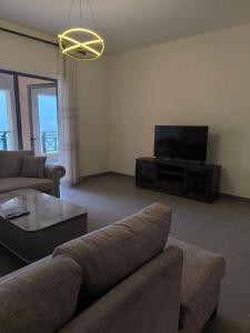 a living room with a couch and a flat screen tv at EP2 Samarah Resort in Sowayma