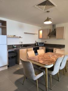 a kitchen with a wooden table and chairs and a refrigerator at EP2 Samarah Resort in Sowayma