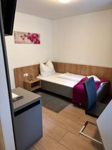 a small room with a bed and a desk at Pension SUNNSEITN - Gastronomie - Café - Weinkeller in Haslach an der Mühl