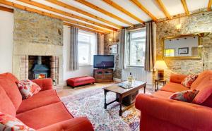 a living room with red couches and a fireplace at 3 Bed in Craster oc-79891 in Craster