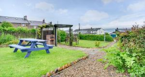 a blue picnic table in the grass in a garden at 3 Bed in Craster oc-79891 in Craster