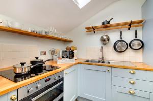 a kitchen with white cabinets and a stove with pots and pans at 2 Bed in Kettlewell oc-ds985 in Kettlewell +6 photos