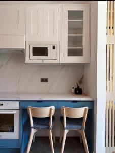 two chairs sitting at a kitchen counter with a microwave at The Balaton Nest! in Alsóörs